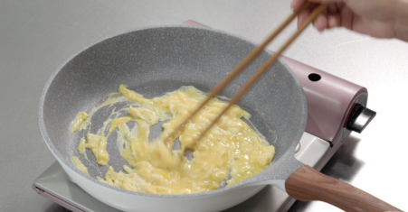 製作添加於蓋飯上的炒滑蛋。將雞蛋打入盆子中打散。在溫熱的平底鍋中倒入少許油，加入打散的雞蛋，稍微攪拌加熱。將完成的炒滑蛋倒入盤中。
