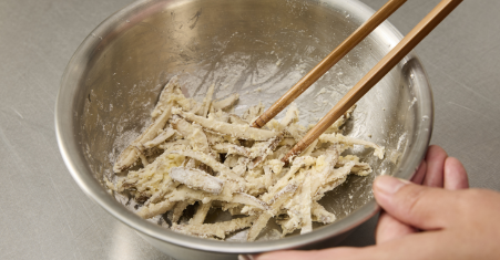 Drain off the water from the burdock root slices and put them in a bowl. Put 3 tablespoons of wheat flour, grated cheese, and a small amount of salt and pepper in the bowl, and stir the ingredients until all come together.
If moisture is insufficient, add a small amount of water.